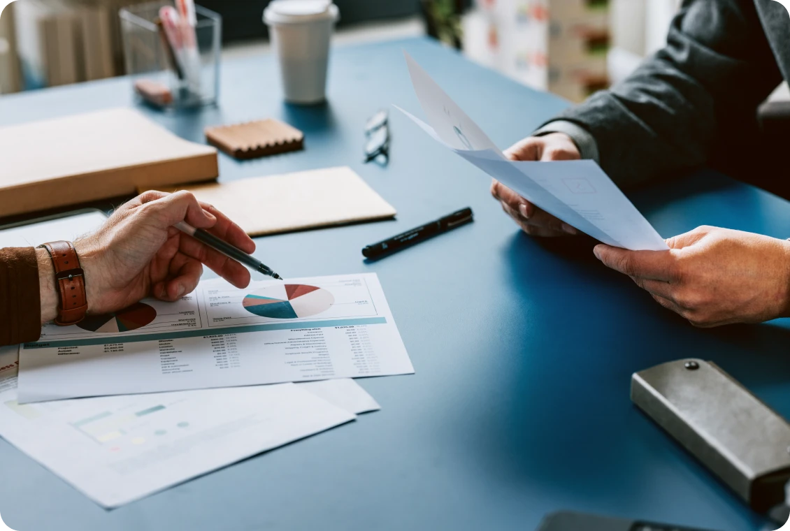 Team discussion with paperwork and graphs