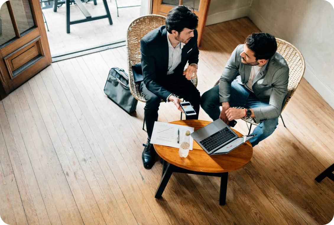 Two men discussing over laptop